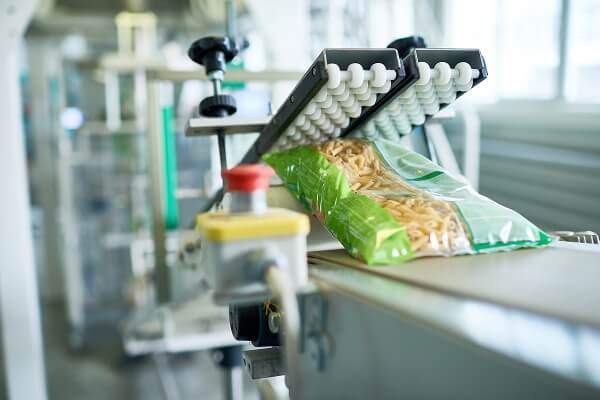 Bag of pasta being sealed on an automated packaging line in a food production facility